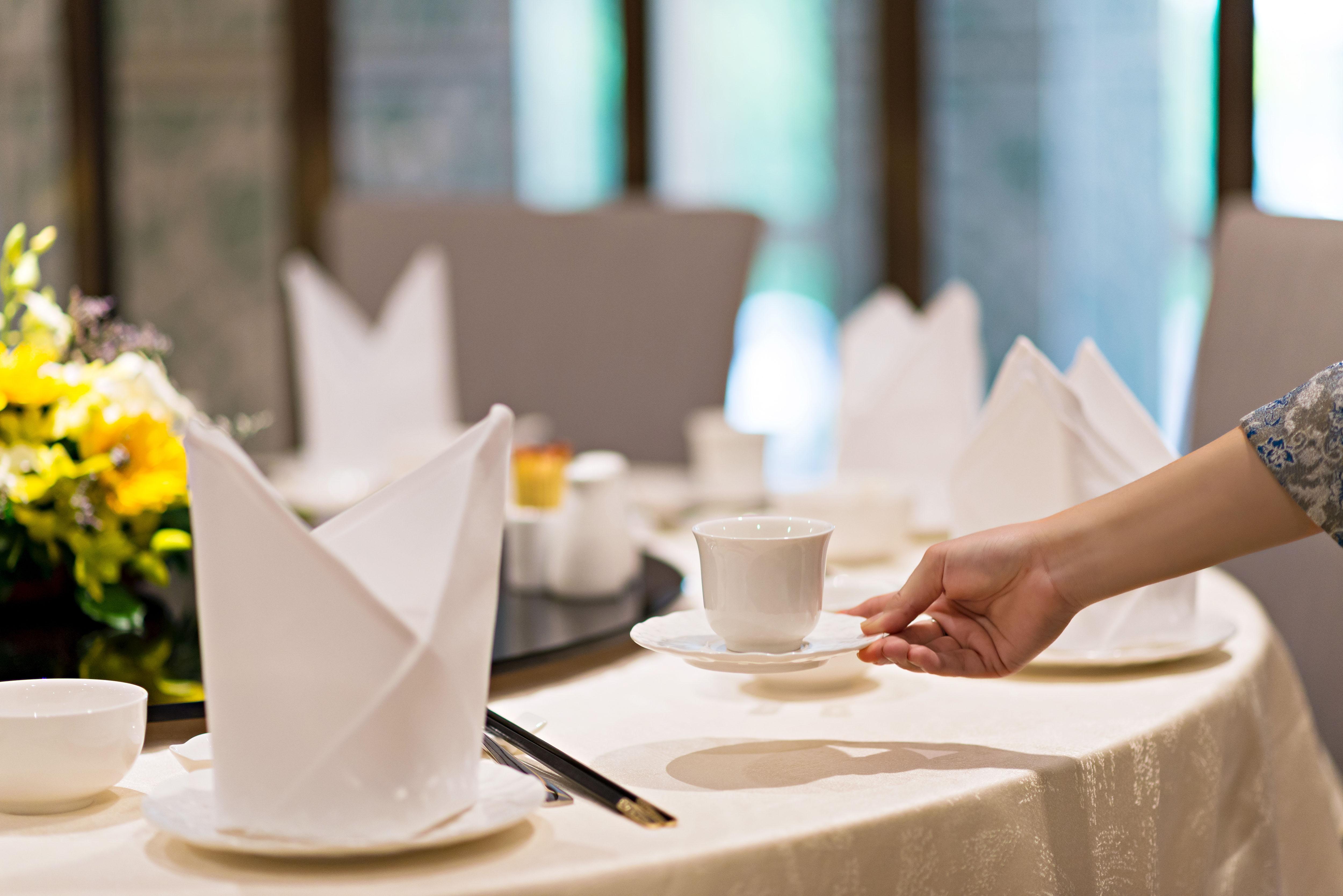 Eastin Grand Hotel Saigon Хошимін Екстер'єр фото A server sets a table at a restaurant.